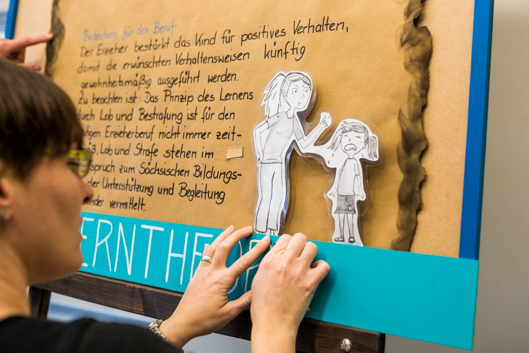 Eine Auszubildende gestaltet ein Plakat.