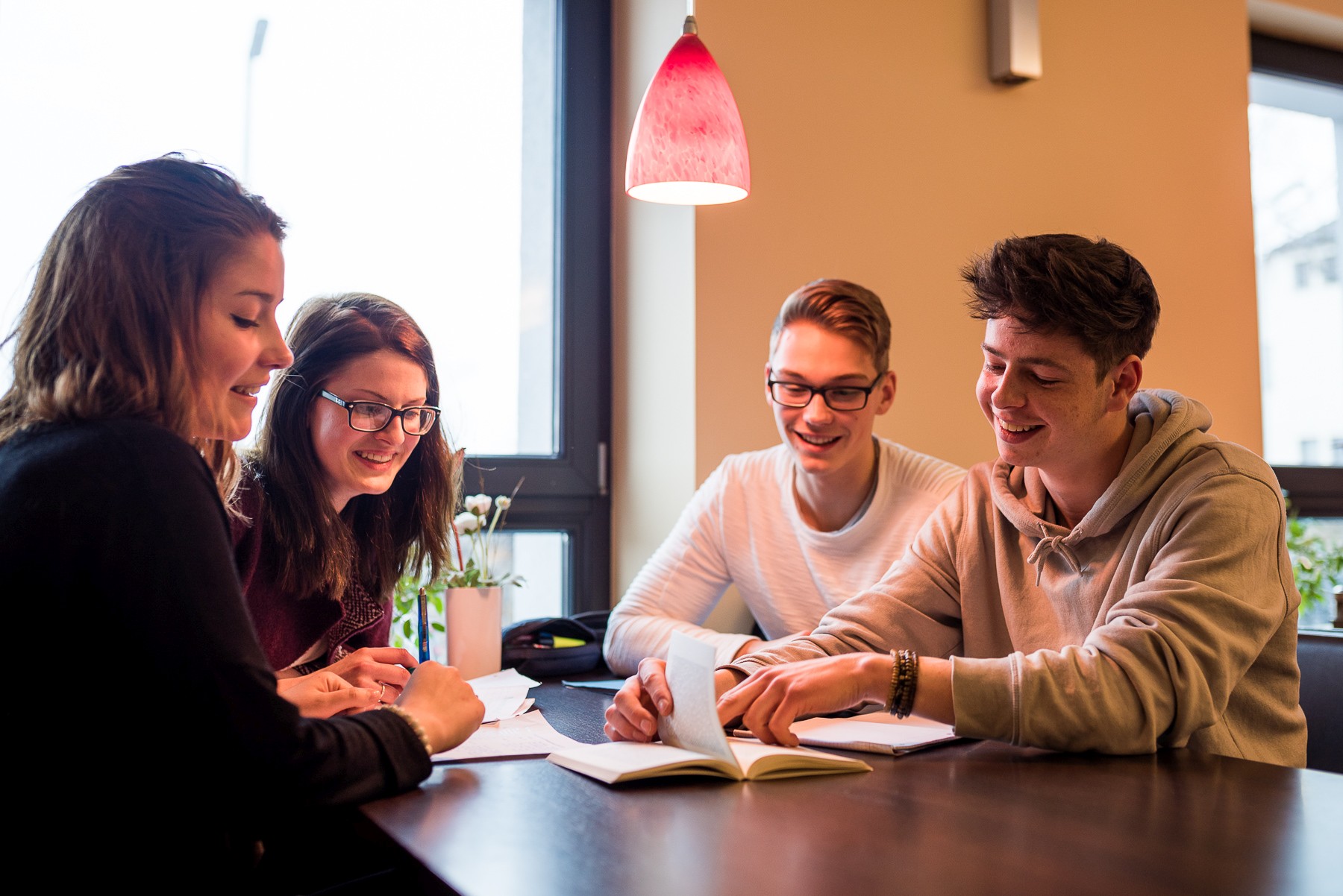 Fachoberschule Vier Schülerinnen und Schüler sitzen an einem Tisch und besprechen eine Gruppenaufgabe.
