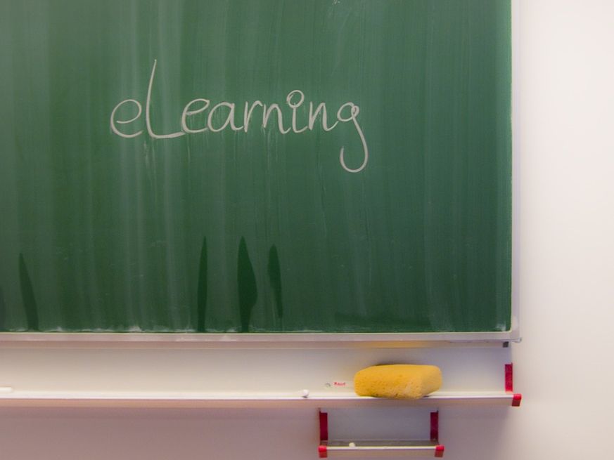 Auf einer Schultafel steht das Wort "e-Learning" geschrieben.