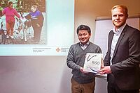 Der Bürgermeister von Arita und Werkstattleiter Michael Druch überreichen sich Gastgeschenke.