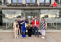 Sieben Personen, darunter das Ehepaar Richter, stehen mit einem Strauß Blumen vor dem Eingang des DRK Landesverbandes Sachsen 