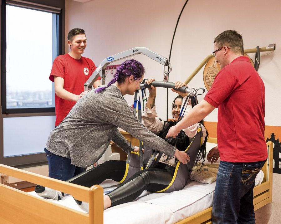 Die Auszubildenden lernen, wie man unmobile Patientinnen und Patienten durch eine Vorrichtung ins Krankenbett hebt.