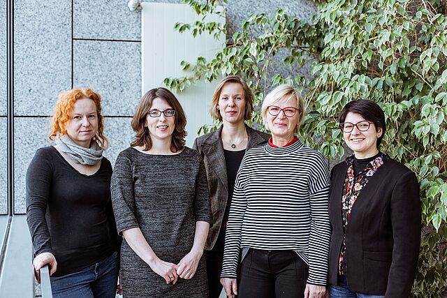 Fünf Mitarbeiterinnen des Projektes "Vielfalt in Sachsen" stehen vor einer großen Pflanze und lächeln in die Kamera.