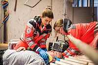2 Notfallsanitäterinnen versorgen einen Verletzten im Rahmen einer Übung.