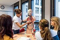 Eine Ausbilderin zeigt den Schülerinnen am Torso-Modell den Aufbau und die Funktionsweise des menschlichen Körpers.